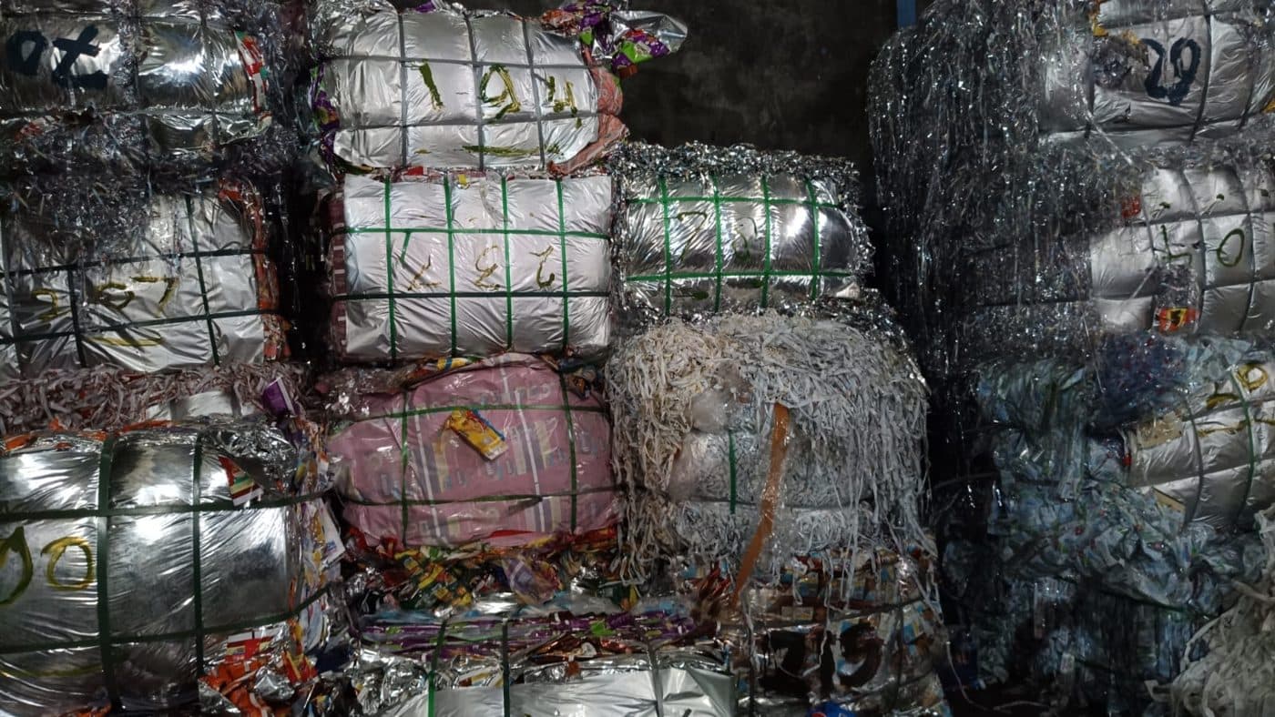 Bal-bal film waste rotogravure — sisa cetak kemasan terkompres dan diikat, ditumpuk sebagai bahan baku daur ulang